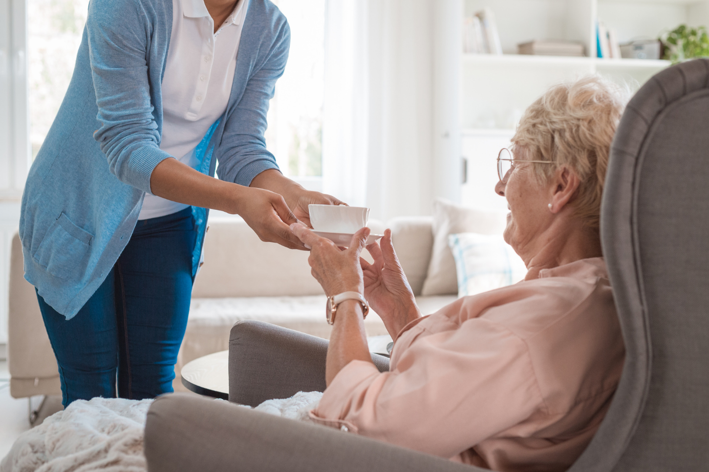 Resident being served tea by staff at Enrogel Health.